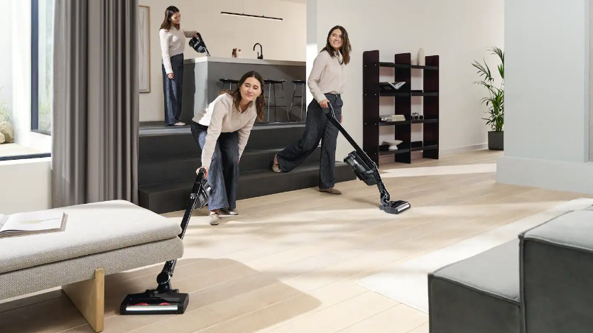 Eine Frau nutzt den Miele Triflex HX3 flexibel in verschiedenen Positionen beim Staubsaugen.